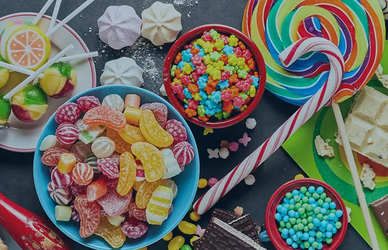 Colorful assortment of candies, lollipops, and confections containing synthetic food dyes—highlighting the challenge food manufacturers face under new U.S. dye regulations and the role of ERP in manufacturing process optimization.